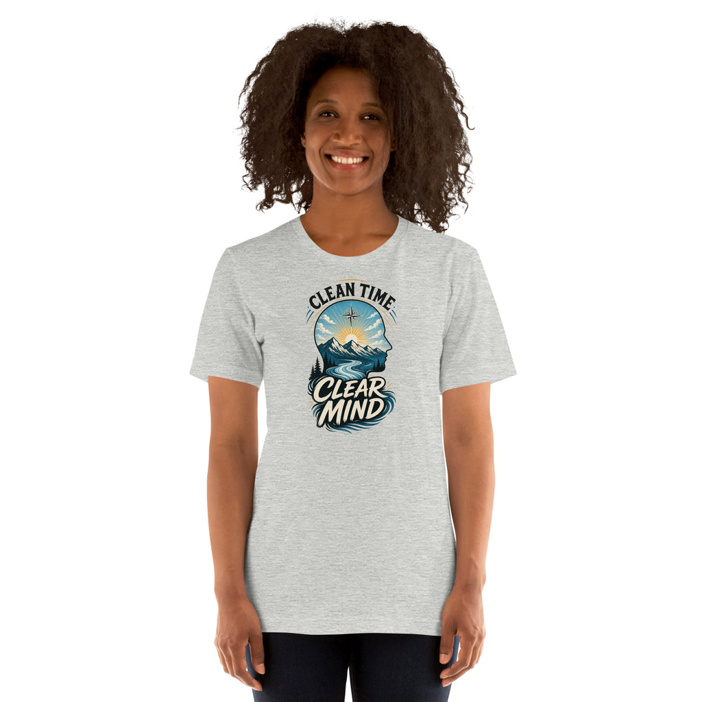 Woman wearing the Athletic Heather Clean Time Clear Mind T-shirt with mountain and sunrise artwork.